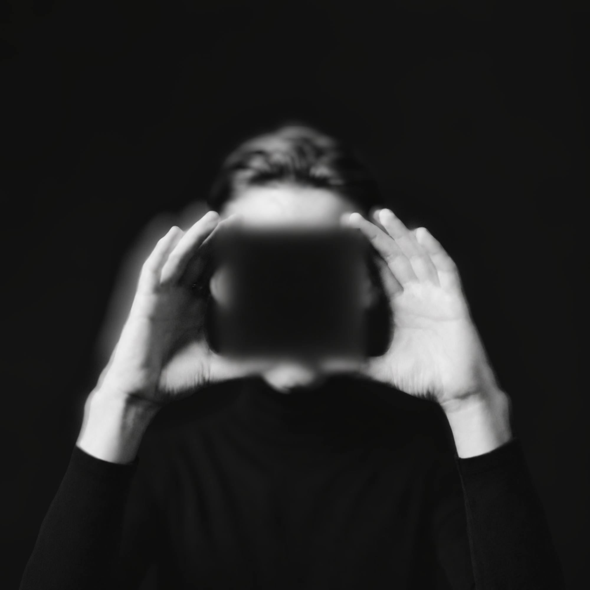 A person in a black turtleneck holding an unreleased Intech Studio module in front of their face, out of focus